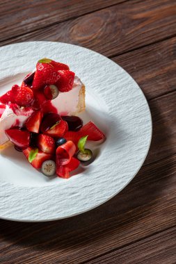 Çilekli reçelli cheesecake, yaban mersinli ve marşmelovlu bir tabakta