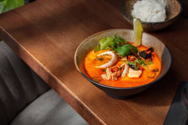 Squid meat with parsley, lime, chili, fish meat and red sauce in a plate on the table with rice in a plate