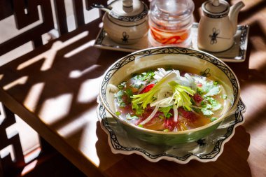 Soğanlı çorba, somon, maydanoz, biber ve spagetti masanın üstünde, arka planda üç kavanoz var.