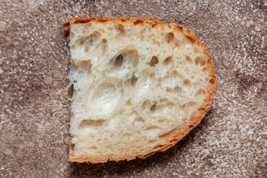 Üç çeşit ekmek tabağı, karabuğday, buğday ve çavdar. Ekmek keten bir havluya sarılı, koyu bir zemin üzerinde, kahve rengi. Yakınlarda dilimlenmiş ekmek parçaları, ekşi kremalı bir kase, yeşil soğan filizi var.