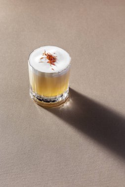 penicillin cocktail. A cocktail based on single malt whiskey and blended whiskey with a large ice cube, lemon juice, ginger juice, honey syrup. The cocktail is poured into a crystal faceted whiskey glass. Top with citrus foam and a pinch of sage. The