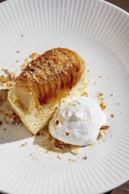 Fried potatoes with honey, sauce, cheesecake, sour cream and hazelnuts in a plate