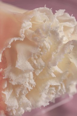 Cocktail with a base of pink gin, strawberry cordial, lactic acid solution, luxardo maraschino, mango bermouth, chocolate bitter select. A cocktail and a piece of ice, poured into a short glass with a mesh pattern. Nearby is a transparent plastic sta