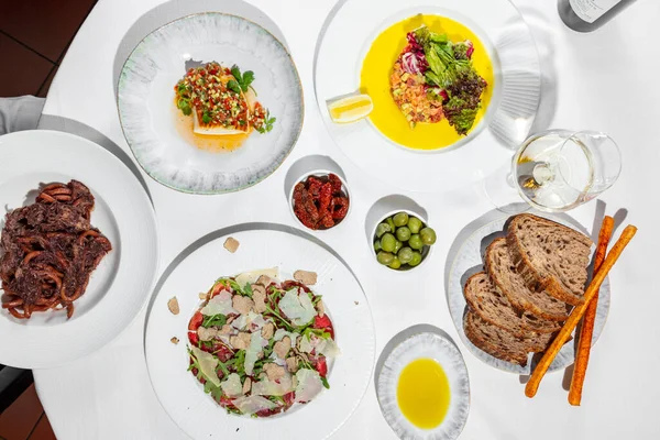 Обед Итальянской Кухни Столе Белой Скатертью Лежат Четыре Тарелки Посудой — стоковое фото