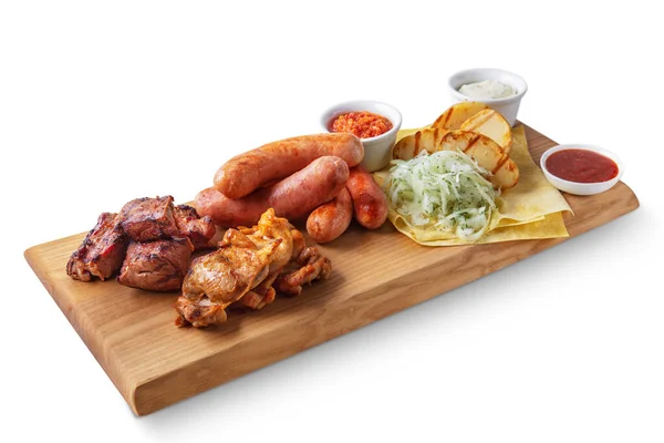 Kızarmış sosis, lahana, lavaş, kızarmış patates, domuz ve tavuk şişleri beyaz bir zeminde duran farklı soslar.