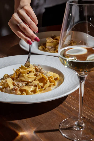 Female Hand Winds Spaghetti Mushrooms Parmesan Fork Plate Table Glass — ストック写真