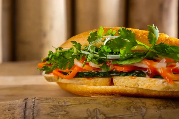 Jambonlu, fesleğenli, maydanozlu, soğanlı, ketçaplı, domatesli ve kabaklı bir sandviç.