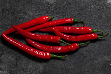 Chili biberi siyah, taş bir arka planda yatar. Üst görünüm.