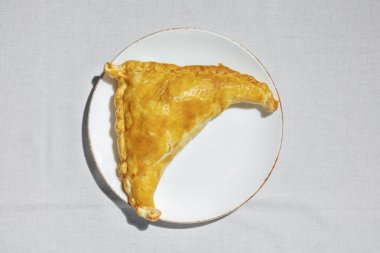 Kıymalı kuzu, baharat ve otlu Khachapuri. Üçgen khachapuri. Yemekler seramik tabakta, hafif bir tabakta. Tabak ışıkta. keten kumaş arkaplanı.