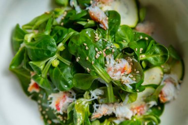 Yengeç etli salata, susam tohumu, fesleğen, kabak ve leylak arkaplanlı fasulye salatası.