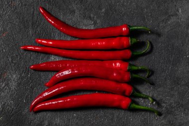 Chili biberi siyah, taş bir arka planda yatar. Üst görünüm.