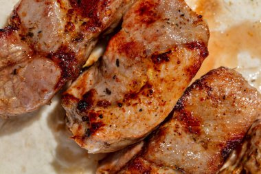 Pork kebab. Four pieces of pork kebab on a sheet of thin Armenian lavash with a mix of greens and radish salad. The food lies on a ceramic plate, on a light tablecloth.
