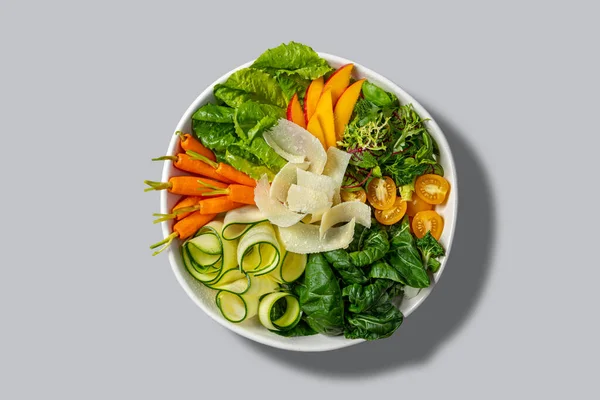将各种类型的蔬菜和年轻的胡萝卜与陶瓷中的意粉混合在一起 用灰色背景的浅色碗 — 图库照片
