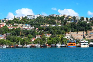 view of a city with a small boat in front, in the mediterranean coast of the island of the