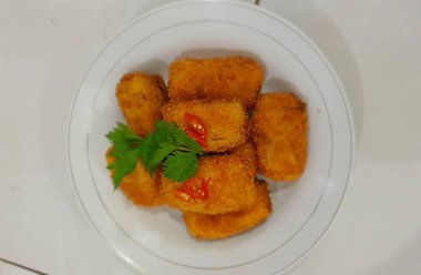 Soslu ve peynirli kızarmış balık.