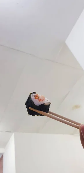 白い背景に箸で回転する寿司 — ストック写真