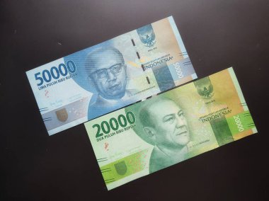 West Java on July 2022. A blue fifty thousand rupiah bill and a green twenty thousand rupiah note.
