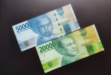 West Java on July 2022. A blue fifty thousand rupiah bill and a green twenty thousand rupiah note.
