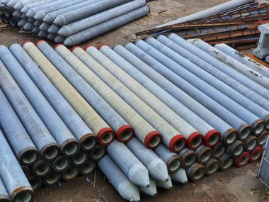 Pile of precast concrete spun pile in a construction project stockyard.