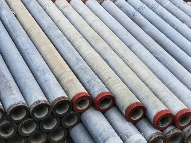 Pile of precast concrete spun pile in a construction project stockyard.