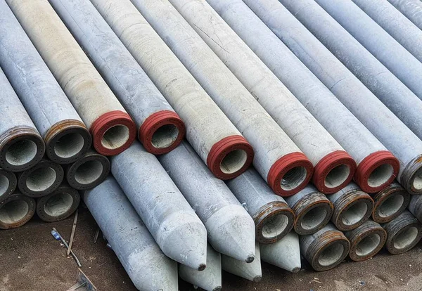 Pile of precast concrete spun pile in a construction project stockyard.