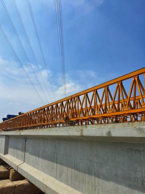 Several girders are arranged in the stockyard for the preparation of erection concrete precast girders using a yellow gantry launcher.