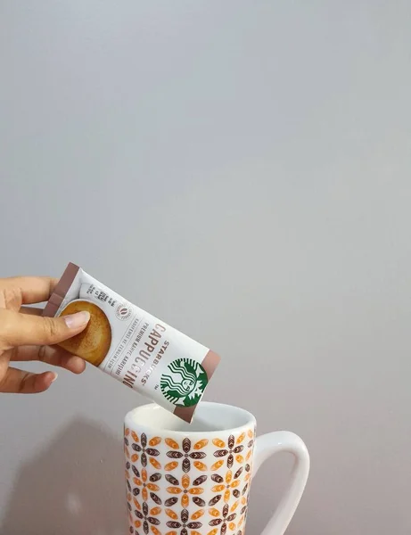 Ένα Χέρι Ρίχνει Ένα Premium Στιγμιαίο Φακελάκι Καφέ Καφέ Starbucks — Φωτογραφία Αρχείου
