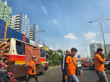 Jakarta in July 2022. Jakarta soccer supporters are mobilizing themselves to the stadium by using an orange bus and orange shirt to watch a match in a stadium.