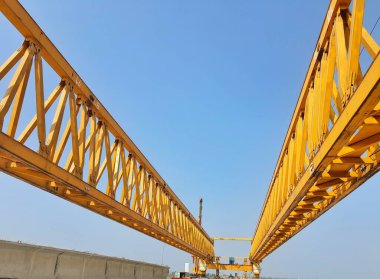 This is the steel structure of a launcher gantry that will be used for erection precast concrete I Girder (PCI Girder) across the river . This yellow gantry launcher comes from China with a capacity of up to 140 tons, with a maximum launch speed of 4