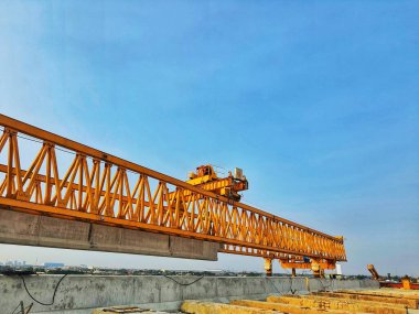 This is the steel structure of a launcher gantry that will be used for erection precast concrete I Girder (PCI Girder) across the river . This yellow gantry launcher comes from China with a capacity of up to 140 tons, with a maximum launch speed of 4