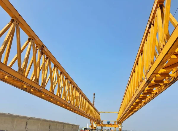 This is the steel structure of a launcher gantry that will be used for erection precast concrete I Girder (PCI Girder) across the river . This yellow gantry launcher comes from China with a capacity of up to 140 tons, with a maximum launch speed of 4