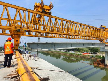This is the steel structure of a launcher gantry that will be used for erection precast concrete I Girder (PCI Girder) across the river . This yellow gantry launcher comes from China with a capacity of up to 140 tons, with a maximum launch speed of 4