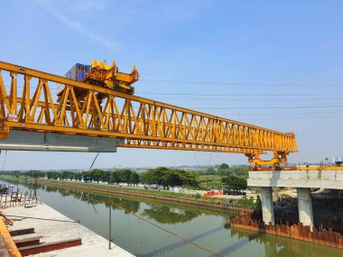 This is the steel structure of a launcher gantry that will be used for erection precast concrete I Girder (PCI Girder) across the river . This yellow gantry launcher comes from China with a capacity of up to 140 tons, with a maximum launch speed of 4