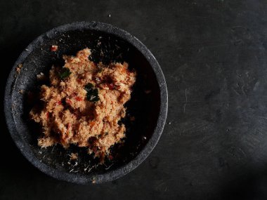 Grated coconut is mixed with spices consisting of garlic, chili, sugar, palm sugar, salt and lime leaves. The taste is spicy and savory with a little sweetness, very good when mixed with vegetables. Very suitable for dieting. In this photo, grated co