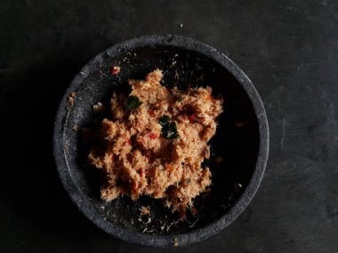 Grated coconut is mixed with spices consisting of garlic, chili, sugar, palm sugar, salt and lime leaves. The taste is spicy and savory with a little sweetness, very good when mixed with vegetables. Very suitable for dieting. In this photo, grated co