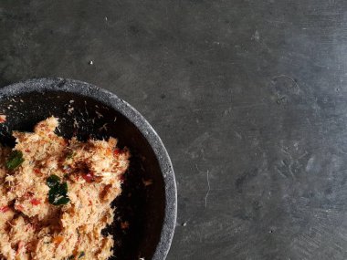 Grated coconut is mixed with spices consisting of garlic, chili, sugar, palm sugar, salt and lime leaves. The taste is spicy and savory with a little sweetness, very good when mixed with vegetables. Very suitable for dieting. In this photo, grated co