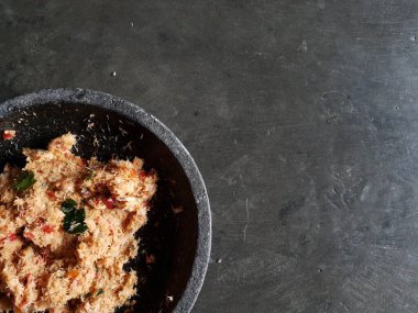 Grated coconut is mixed with spices consisting of garlic, chili, sugar, palm sugar, salt and lime leaves. The taste is spicy and savory with a little sweetness, very good when mixed with vegetables. Very suitable for dieting. In this photo, grated co