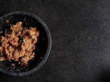 Grated coconut is mixed with spices consisting of garlic, chili, sugar, palm sugar, salt and lime leaves. The taste is spicy and savory with a little sweetness, very good when mixed with vegetables. Very suitable for dieting. In this photo, grated co