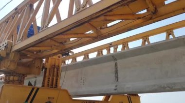 This is the steel structure of a launcher gantry that will be used for erection precast concrete I Girder across the river . This yellow gantry launcher comes from China with a capacity of up to 140 tons, with a maximum launch speed of 4 m / min.