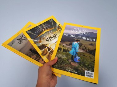 West Java in August 2022. A hand holds the Indonesian version of the National Geographic magazine. National Geographic is the official journal of the National Geographic Society which has provided information about the world and all its contents glob
