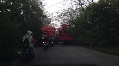 Cakarta, Endonezya Temmuz 2022. Çok büyük bir ağır ekipman dar bir köy yolundan geçiyor..