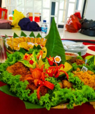 Nasi Tumpeng, sarı pirinç külah şeklinde ve yanında mezeler ve sebzelerle donatılmış. Endonezya 'da bu yiyecekler genellikle bir şeyleri kutlamak içindir..