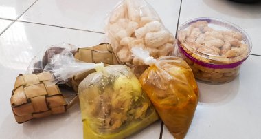 Pansiyondaki çocuklar için naylona sarılı bayram yemekleri, tavuk çorbası, kızarmış patates sosu ve pirinç keki veya ketupatla tamamlanmış lodeh sebze paketleri..