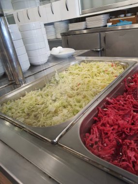 Türk salatası müşterilere vermek için bir restoran masasına güzelce yerleştirilmiş. Bu salatanın kompozisyonu lahana, kırmızı lahana veya soğan ve maydanoz yapraklarından oluşmaktadır. Bu salata zeytinyağı ve limon sosuyla yenir..