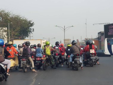 Cakarta, Endonezya Temmuz 2019. Bir grup motosikletlinin durup arabaların geçmesini beklemesi trafik sıkışıklığına neden oluyor..