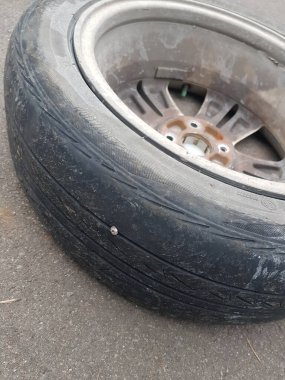 Cakarta, Endonezya Ağustos 2019. Patlak ve sönmüş bir Honda caz lastiğine çivi isabet etmiş. Kötü adamlar sık sık yoldan geçen araçlara çivi çakar..