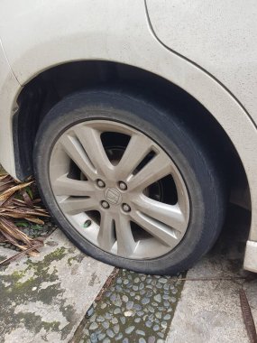 Cakarta, Endonezya Ağustos 2019. Patlak ve sönmüş bir Honda caz lastiğine çivi isabet etmiş. Kötü adamlar sık sık yoldan geçen araçlara çivi çakar..