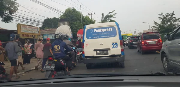 Nisan 2019 'da Batı Cava. Atardamar tıkanıklığında motosiklet ve arabaların arka görüntüsü. Trafik sıkıştığında, araç yavaş çalışır ve hatta geçici olarak durur..