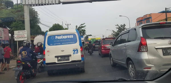 Nisan 2019 'da Batı Cava. Atardamar tıkanıklığında motosiklet ve arabaların arka görüntüsü. Trafik sıkıştığında, araç yavaş çalışır ve hatta geçici olarak durur..