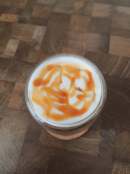 Glass of Ice Salted Caramel Macchiato. Coffee with a mixture of milk and caramel syrup which is very fresh, sweet, slightly bitter and salty is very delicious enjoyed on a hot day.